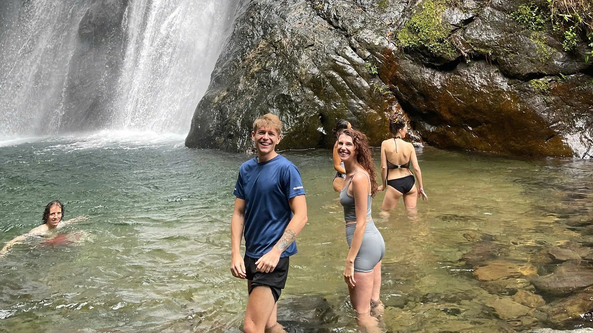 Guests swimming under A Boong waterfall