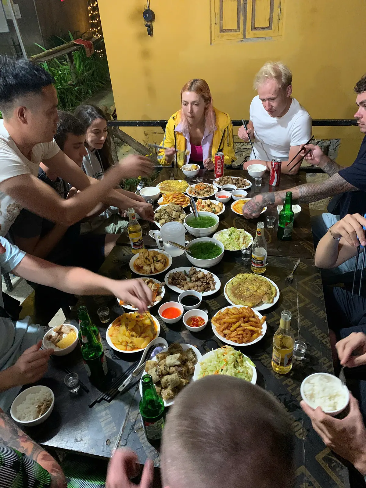 The whole group around a long table for dinner at the homestay