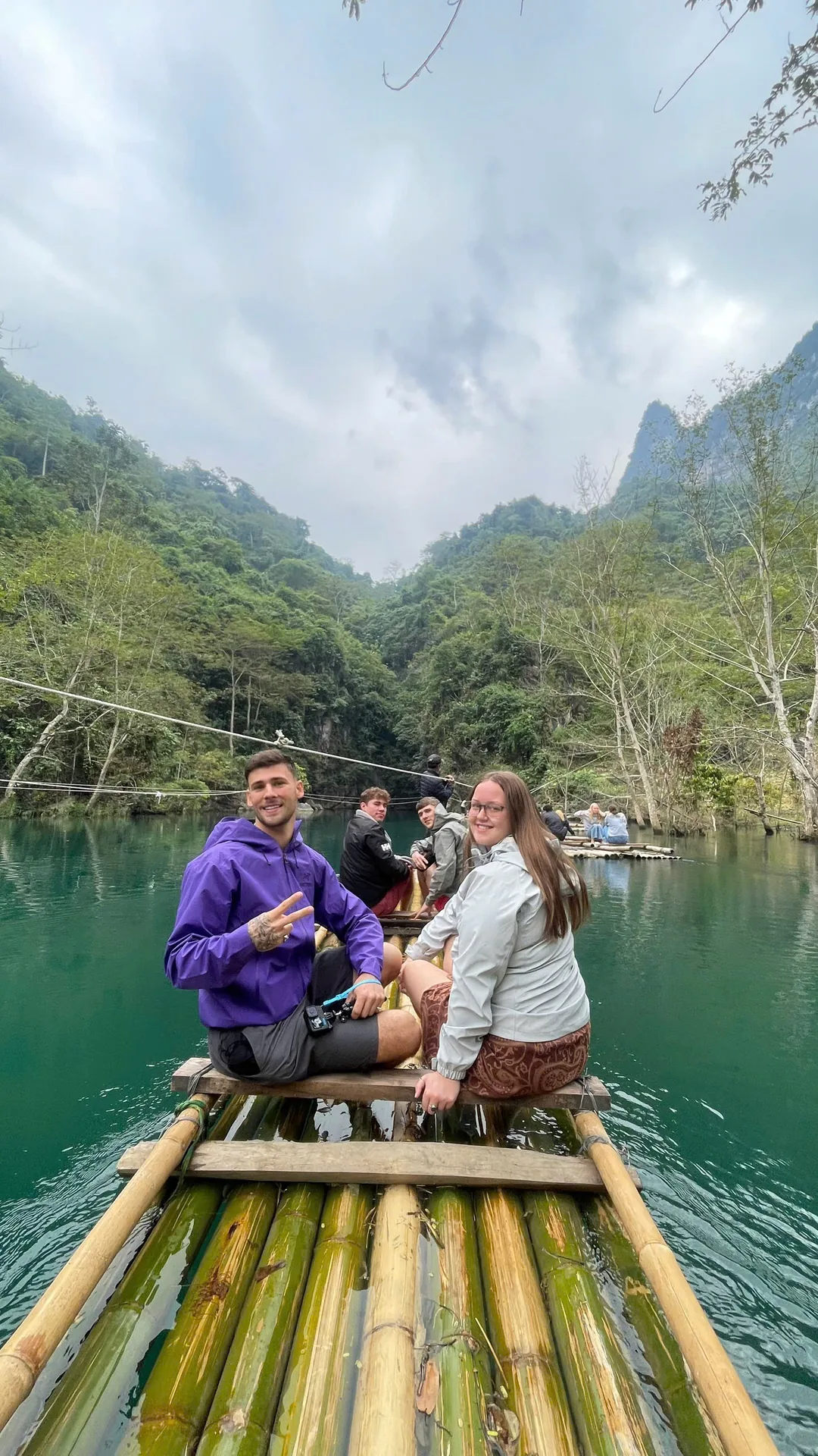 Two guests on a bamboo raft on the Hangtham Lin River near Du Gia