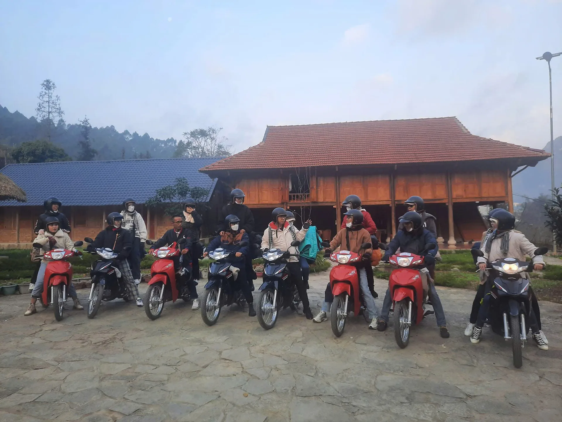 Freedom riders and guides resting outside a village house on the Ha Giang Loop